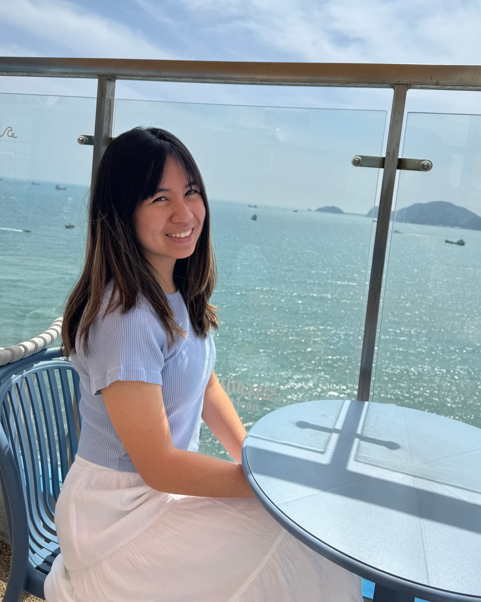 Madeleine Chan sitting at an outdoor table by the water